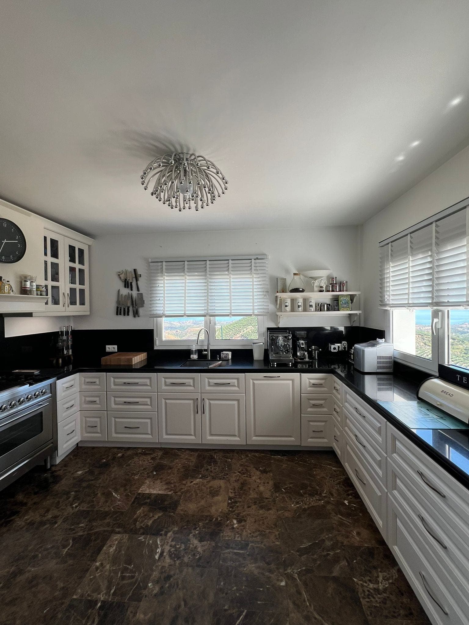 Fitted kitchen with white cabinetry and sea-facing window